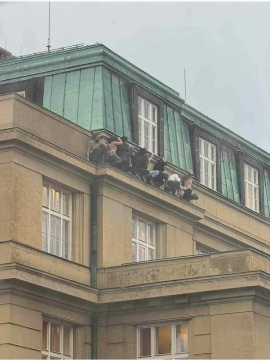 Students hide on a ledge as a shooter stalks Prague from a university roof. Picture: Supplied