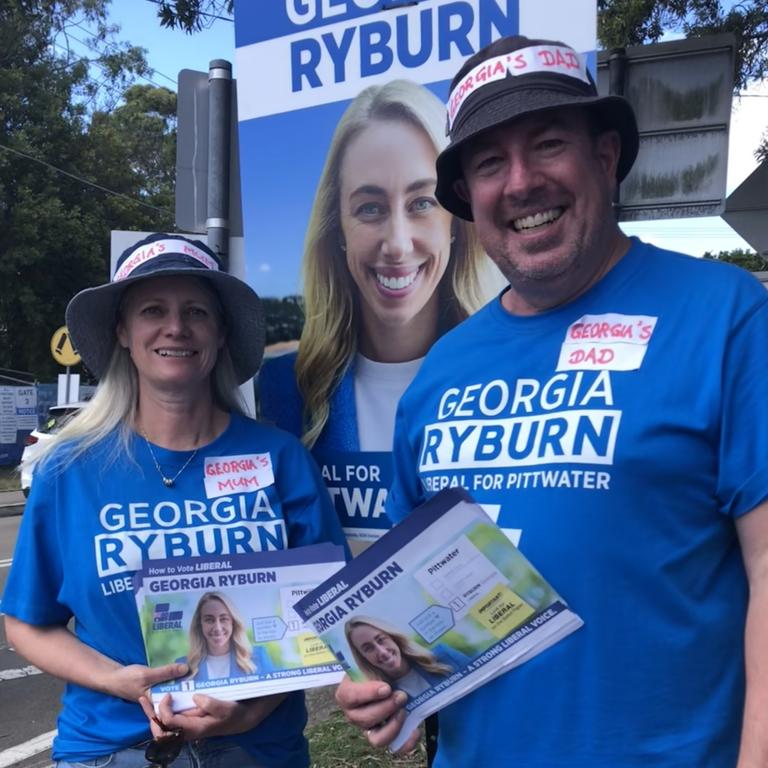 The parents of the Liberal candidate in the Pittwater by-election, Georgia Ryburn, Meredith and Peter Downey, were handing out how-to-vote pamphlets for their daughter at the Ted Blackwood Memorial Hall in Warriewood on Saturday. Picture: Jim O’Rourke.