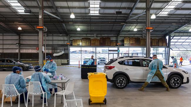 People get tested by Australian Defense Force personnel for COVID-19 at a drive through testing site at Flemington. Picture: Getty Images