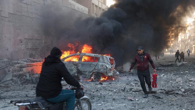 People try to extinguish fires following an airstrike that targeted Syria's rebel-held northern city of Idlib on December 2. Picture: Omar Haj Kadour / AFP