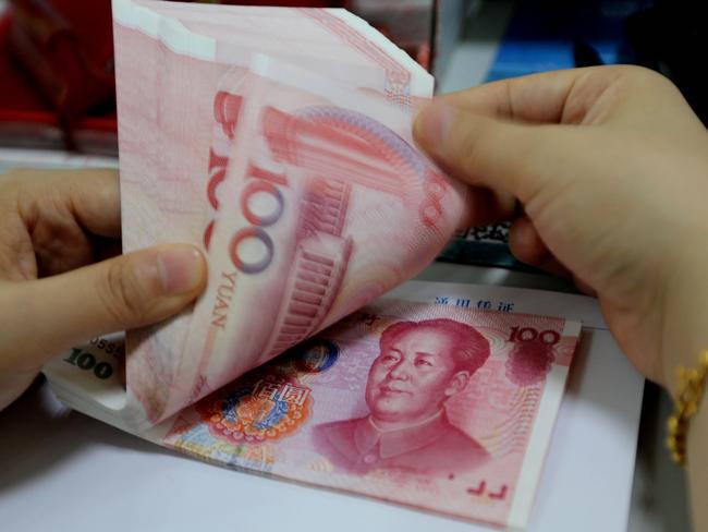 A teller counts yuan banknotes in a bank in Lianyungang, east China's Jiangsu province on August 11, 2015. China's central bank on August 11 devalued its yuan currency by nearly two percent against the US dollar, as authorities seek to push market reforms and bolster the world's second-largest economy. CHINA OUT AFP PHOTO