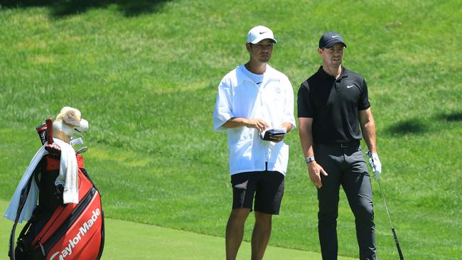 Rory McIlroy talks with his caddie Harry Diamond on the ninth hole.