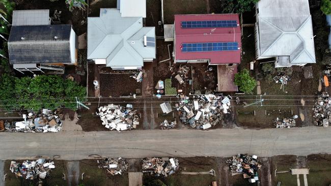 Aerial photos show the flood waters have receded but the clean-up work has just begun with piles of rubbish, household goods and furniture being thrown out of homes and business and onto the street ready for collection. Picture: Toby Zerna