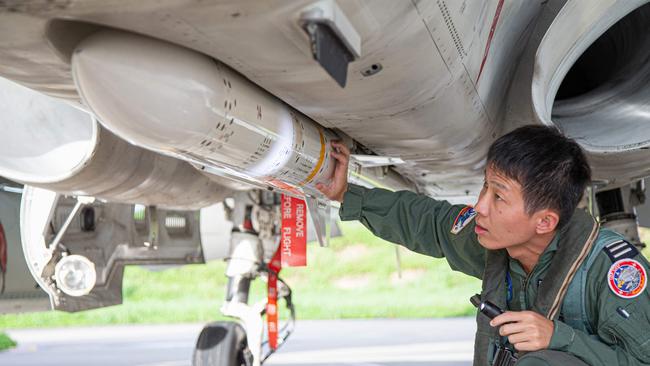 A Taiwanese air force pilot inspects a missile on his aircfat. Picture: AFP