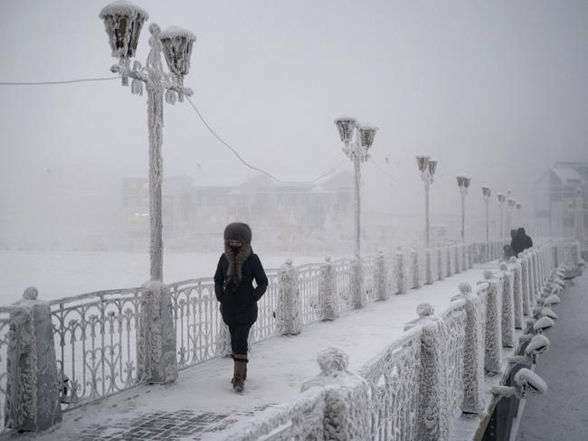 A woman walks over an ice-encrusted bridge in Yakutsk Village of Oymyakon. Picture: Amos Chapple/REX/Shutterstock/Australscope