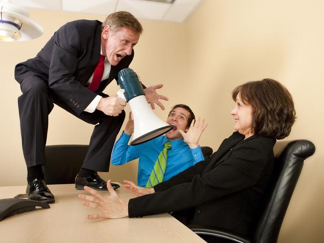 Crazy boss standing on conference table with megaphone yelling at shocked employees. property spruiker, aggressive salesman, generic