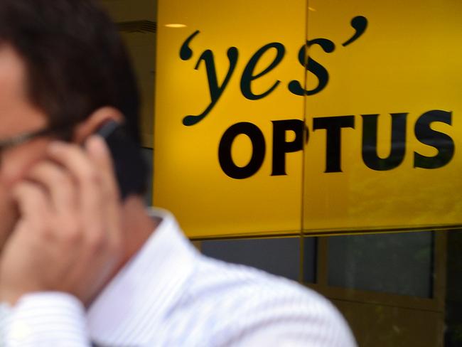 A person talks on his mobile phone next to an Optus shop in Brisbane, Wednesday, May 2, 2012. The telco giant is slashing 750 jobs as part of a restructure. (AAP Image/Dan Peled) NO ARCHIVING