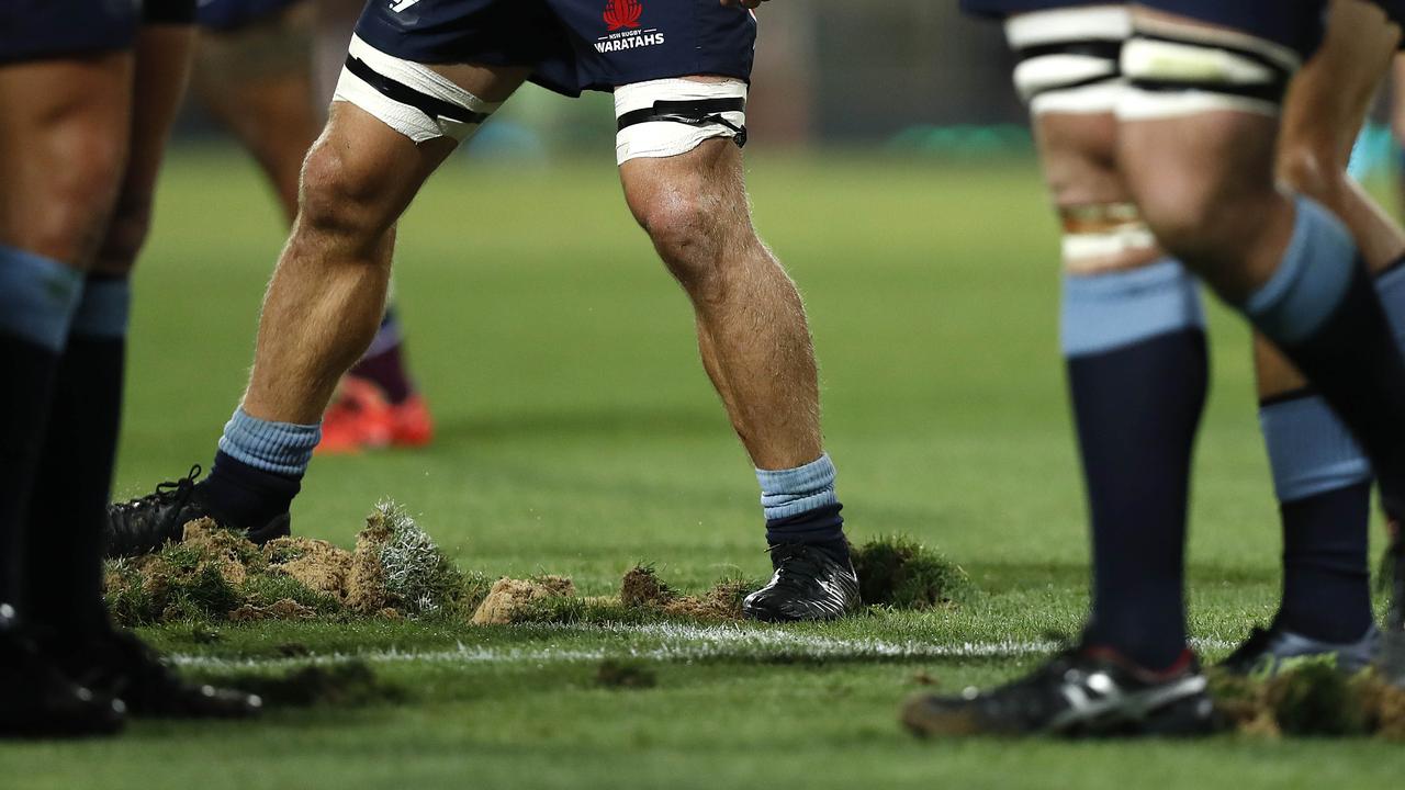 Players replace divots after a scrum at the Sydney Cricket Ground.