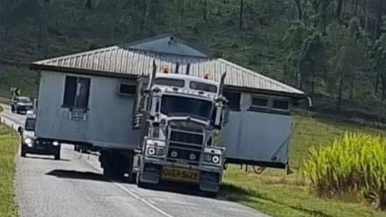 Drivers pulled over to the side of the road to allow the truck to pass while traffic built up in both lanes behind the house.