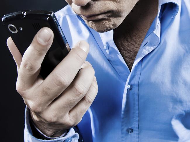 Angry man looking at mobile phone. Call back. Generic image.