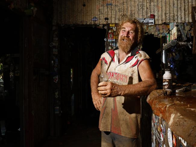 Lions Den Hotel grounds keeper Craig "Prickles" Thorn, 67, enjoys a cold Great Northern beer at the public bar which is still covered in mud from the Annan River in December, 2023. Picture: Brendan Radke