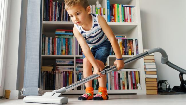 Little kid using vacuum cleaner at home - Small boy cleaning floor in apartment - Child doing housework having fun - side view full length in summer day - childhood development real people concept