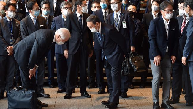 New Japanaese Prime Minister Yoshihide Suga, centre, bows as he is welcomed following the departure of outgoing prime minister Shinzo Abe on Wednesday. Picture: AFP