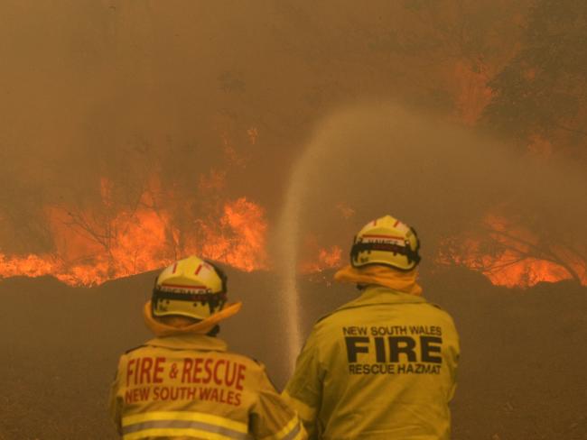 Firefighters work to contain a bushfire along Old Bar road in Old Bar, NSW, Saturday, November 9, 2019. Two people have been killed and seven others are missing in bushfires in NSW which have also destroyed at least 100 homes. (AAP Image/Darren Pateman) NO ARCHIVING