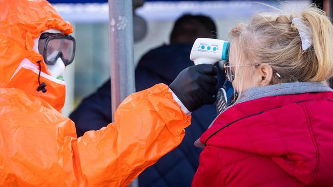 A Polish health official check the temperature of returning Poles crossing the Polish-German border. Picture: ODD ANDERSEN/AFP