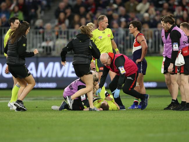 PERTH, AUSTRALIA - AUGUST 17: Umpire Alex Whetton is attended to after being hit in a collision during the round 22 AFL match between the Fremantle Dockers and the Essendon Bombers at Optus Stadium on August 17, 2019 in Perth, Australia. (Photo by Paul Kane/Getty Images)