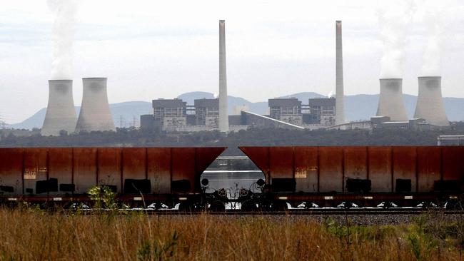 (FILES) This file picture taken on November 4, 2021 shows steam rising from the cooling towers of the Liddell Power Station next to Lake Liddell in the town of Singleton, some 70km (43 miles) from Newcastle, the world's largest coal exporting port. - Australia's oldest coal-fired power plant will shut down on April 28, 2023, as the country, a once-notorious climate straggler, prepares for a seismic shift towards renewable energy. (Photo by Saeed KHAN / AFP) / TO GO WITH: Australia-climate-politics-energy-coal, by Steven TRASK