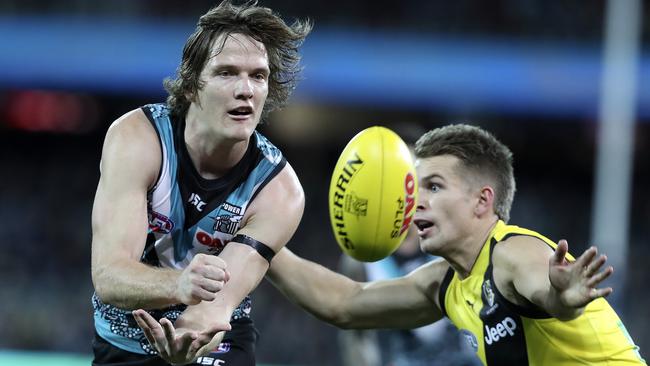 Port’s Jared Polec gets his handpass away from Richmond’s Dan Butler at Adelaide Oval on Fruiday night. Picture: SARAH REED