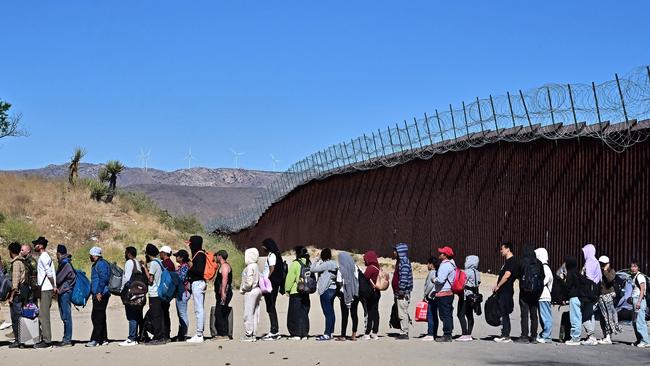 Migrants wait for processing from Customs and Border Patrol agents after walking under intense heat from Mexico into the US. Picture: AFP.