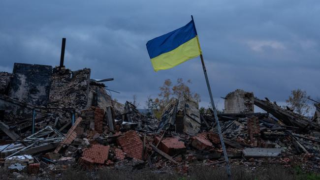 A Ukrainian flag flies above the ruins of buildings destroyed during fighting between Ukrainian and Russian occupying forces. Picture: Getty Images.