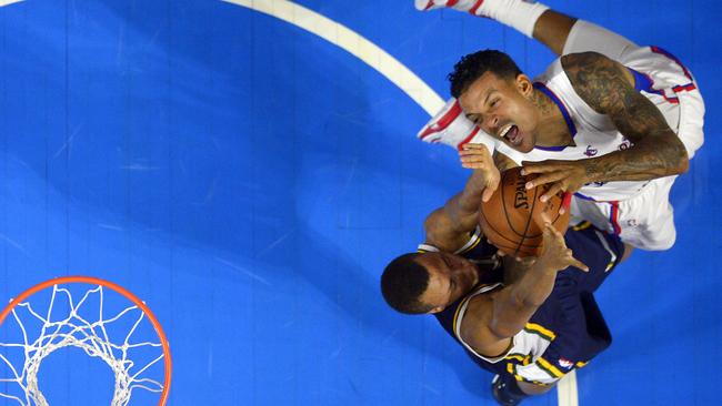 Los Angeles Clippers forward Matt Barnes, top, has his shot blocked by Utah Jazz guard Dante Exum.