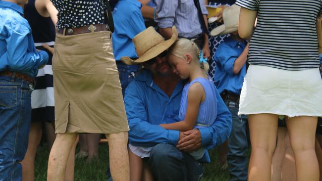 Mr Everett comforts a crying child at the memorial. Picture: Supplied