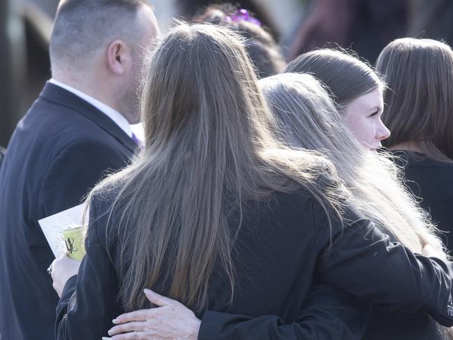 Mourners console each other outside Friday’s service. Picture: Jeremy Piper