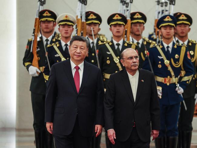 TOPSHOT - Chinese President Xi Jinping (L) and Pakistani President Asif Ali Zardari (R) walk pass the honour guards during the welcome ceremony at the Great Hall of the People in Beijing on February 5, 2025. (Photo by WU HAO / POOL / AFP)