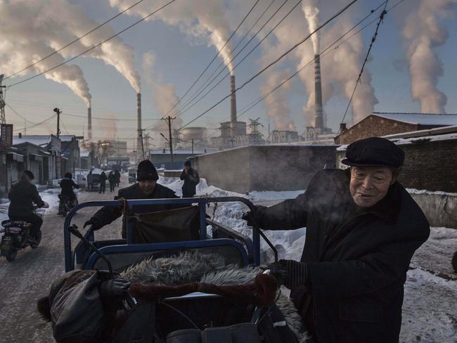 “China’s Coal Addiction” by photographer Kevin Frayer for Getty Images which won first prize in the Daily Life singles category shows Chinese men pulling a tricycle in a neighborhood next to a coal-fired power plant in Shanxi, China, on Nov. 26, 2015. A history of heavy dependence on burning coal for energy has made China the source of nearly a third of the world’s total carbon dioxide (CO2) emissions, the toxic pollutants widely cited by scientists and environmentalists as the primary cause of global warming. (Kevin Frayer/Getty Images, World Press Photo via AP)