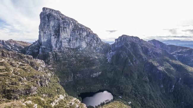 Lake Tahune Hut sits below the peak of Frenchmans Cap on the shore of Lake Tahune.