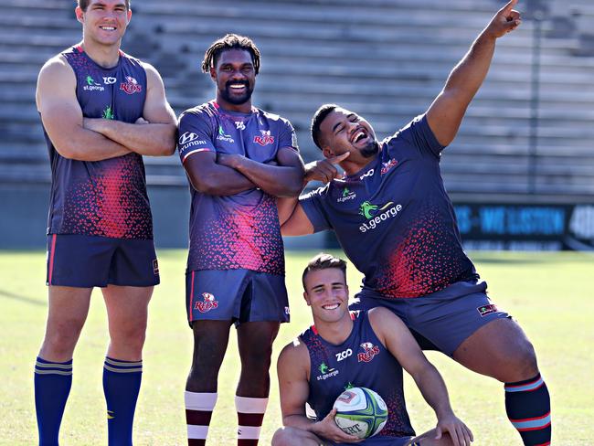 Reds rookie Hamish Stuart (seated) with teammates (l-r) Angus Scott-Young  Moses Sorovi and Taniela Tupou with the socks they will wear on Saturday for Rugby Family Round.