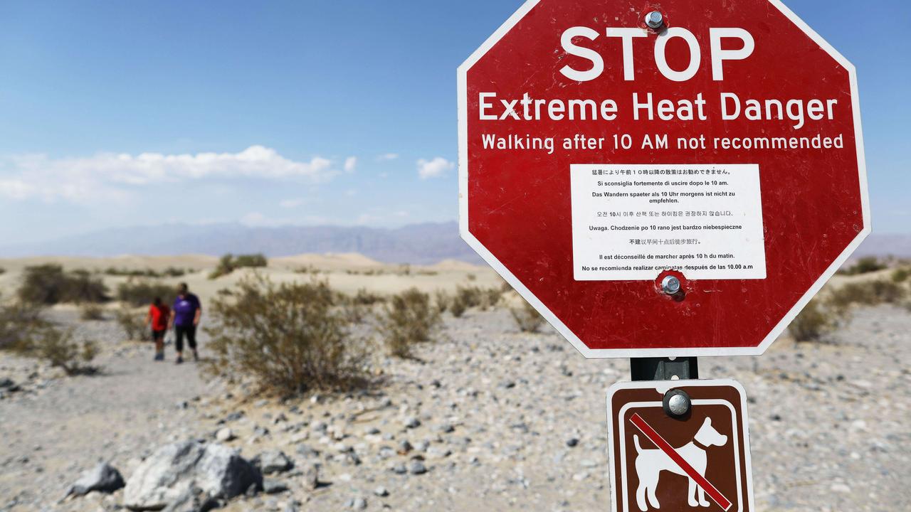 Visitors walk near a sign warning of extreme heat danger on August 17, 2020 in Death Valley National Park, California, US. Picture: Getty Images/AFP