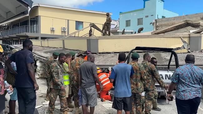 Security forces and rescuers inspecting a damaged car trapped underneath a collapsed building in Vanuatu's capital Port Vila. Picture: Facebook account of Michael Thompson/AFP