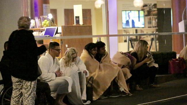 Novotel hotel guests huddle in the cold after being evacuated. Picture: Steve Tyson