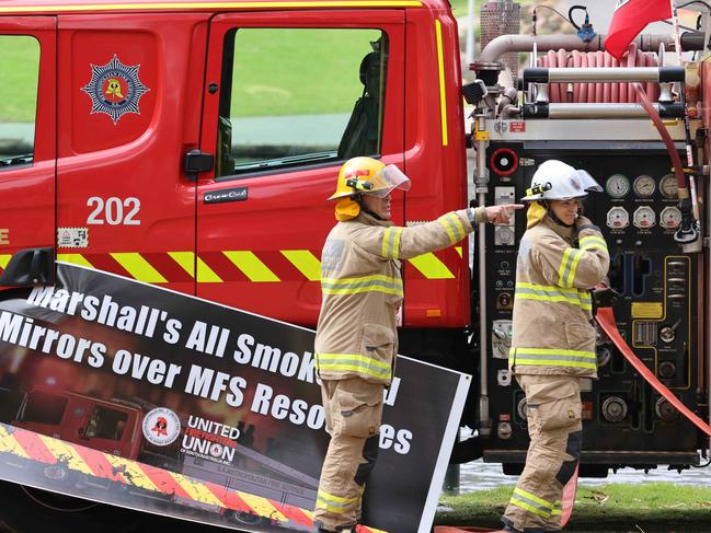 Fire fighters put up placards and flags for the UFU. Picture: Russell Millard