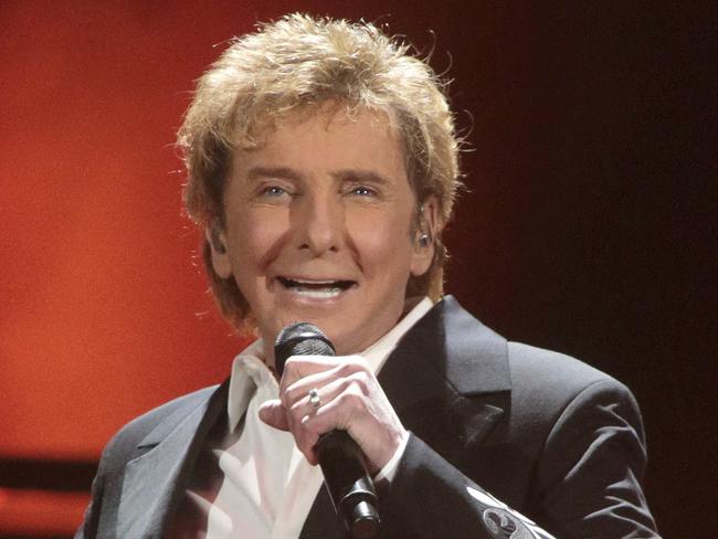 FILE - In this March 17, 2016 file photo, Barry Manilow performs in concert during his "One Last Time! Tour 2016" in Hershey, Pa. Manilow tells People magazine that he hid being gay for decades because he thought he would be disappointing fans if they knew. The 73-year-old music legend married his longtime manager, Gary Kief, in a 2014 ceremony at their home in Palm Springs, Calif. Manilow tells the magazines April 17 issue that keeping their romance out of the media was stressful. (Photo by Owen Sweeney/Invision/AP, File)