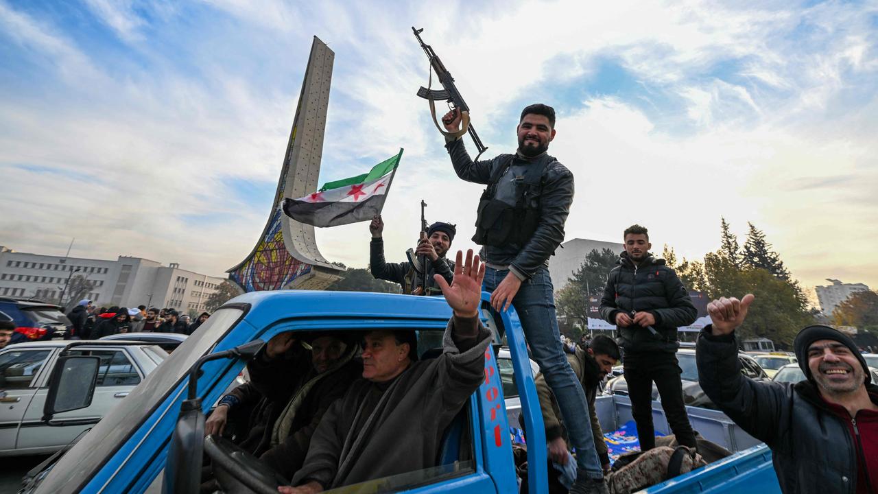 Anti-government fighters cheer from the back of a car at Umayyad Square in Damascus. Picture: Louai Beshara/AFP