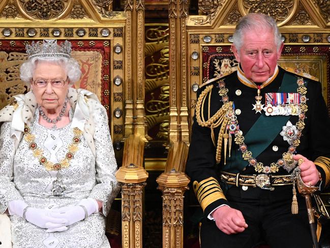 (FILE PIC)  Britain's Queen Elizabeth II (L) takes her seat on the The Sovereign's Throne in the House of Lords next to Britain's Prince Charles, Prince of Wales at the State Opening of Parliament in the Houses of Parliament in London on October 14, 2019. - The State Opening of Parliament is where Queen Elizabeth II performs her ceremonial duty of informing parliament about the government's agenda for the coming year in a Queen's Speech. (Photo by Paul Edwards / POOL / AFP)