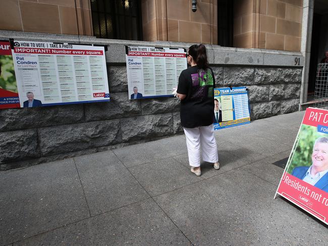 A woman looks at "how to vote" boards in the absence of volunteers in Brisbane. Picture: Getty