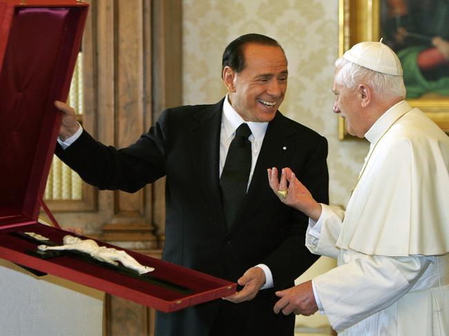 Silvio Berlusconi presents a crucifix to the late Pope Benedict XVI in 2005. Picture: AFP