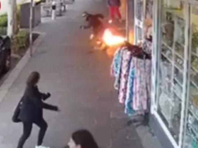 Adults and children have been forced to jump over flames to escape a burning shop on the NSW Central Coast. CCTV allegedly shows a man pouring petrol into the store in The Entrance and on the pavement outside, before setting it alight with the family inside.
