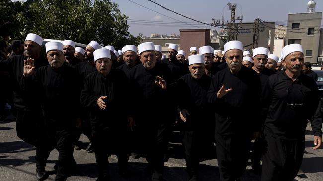 Mourners dress in traditional clothing as they attend the funeral of the child victims. Picture: Getty Images