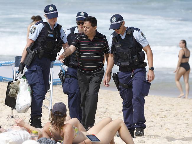 SYDNEY, AUSTRALIA - NewsWire Photos JANUARY 26, 2025: Police escort a man off the beach at Bronte Beach on Australia day.Picture: NewsWire / Damian Shaw