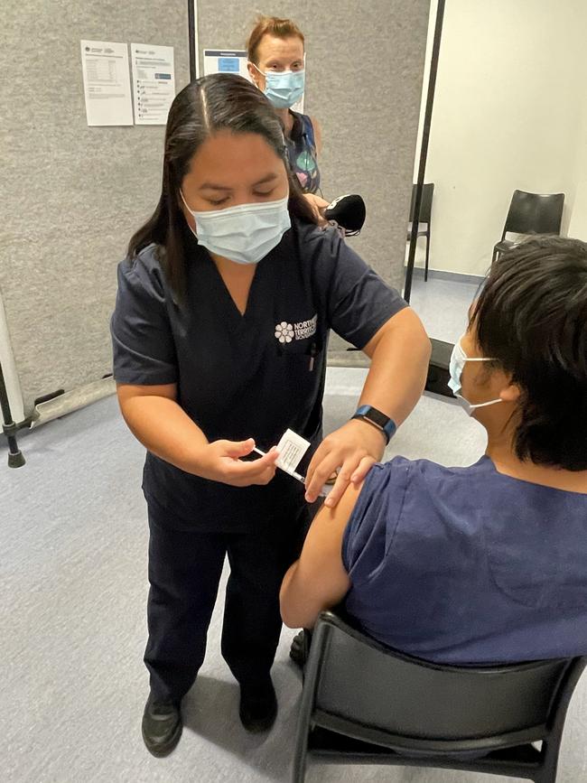 Renal nurse Christine Fabre delivers the first COVID-19 vaccination in Central Australia to pandemic co-ordinator Reinier Cadacio. Picture: DANIEL WOOD