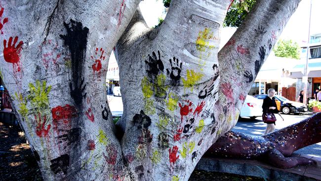 A tree on Boundary St, West End, behind the goanna sculpture, with handprints in the colours of the Aboriginal flag. Picture: David Kelly