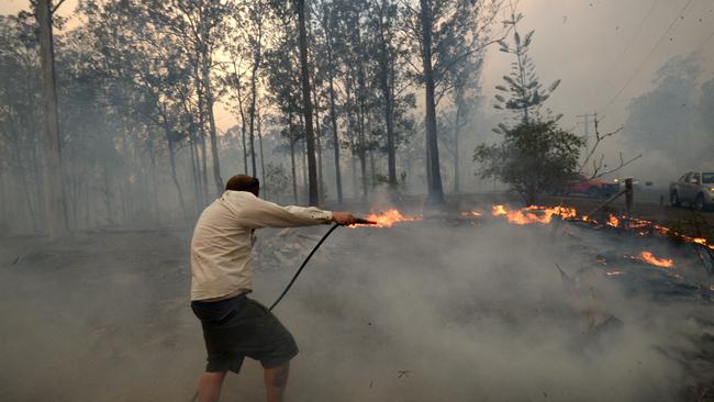 A resident tries to fight a bushfire threatening homes in Rainbow Flat. Picture: Jeremy Piper