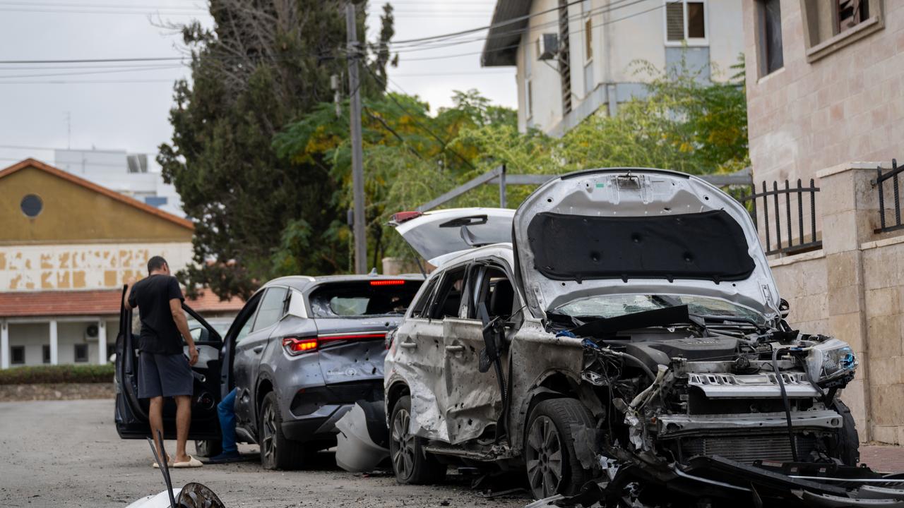 People look at their cars after they were hit by a rocket a in Ashkelon, Israel. Picture: Getty Images