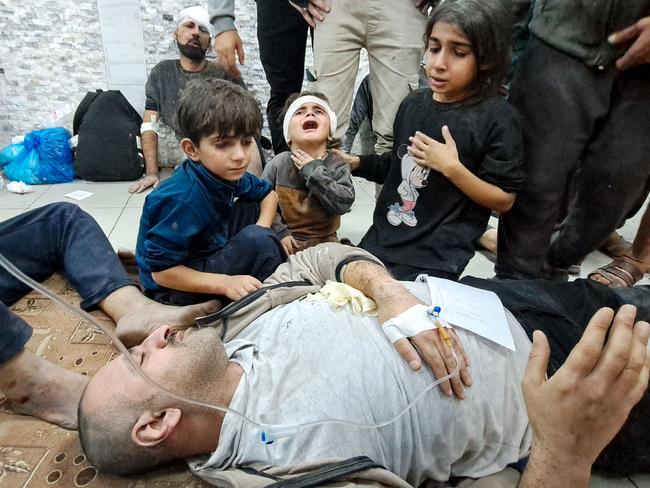 Palestinian children with a wounded man at a hospital in Beit Lahia. Picture: AFP