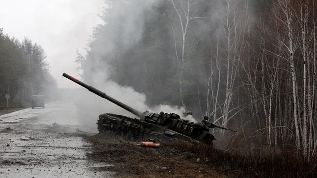 Smoke rises from a Russian tank destroyed by the Ukrainian forces on the side of a road in Lugansk region in February. Picture: AFP