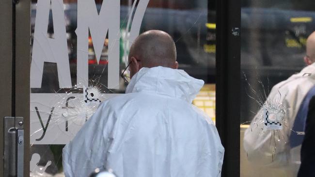 Police forensic teams canvass the bullet-riddled doors at BodyFit Auburn after the shooting, Picture: John Grainger